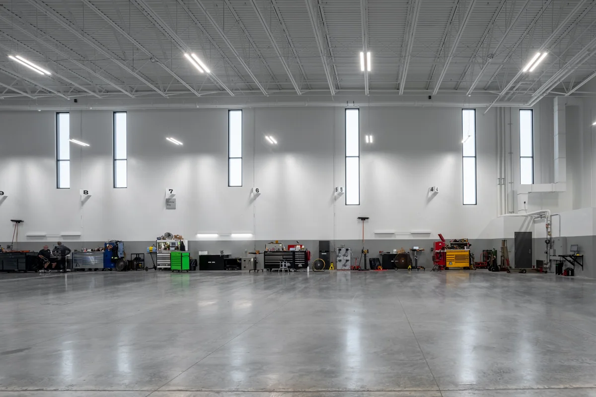 Technician work bays with high-bay lighting and utility connections.